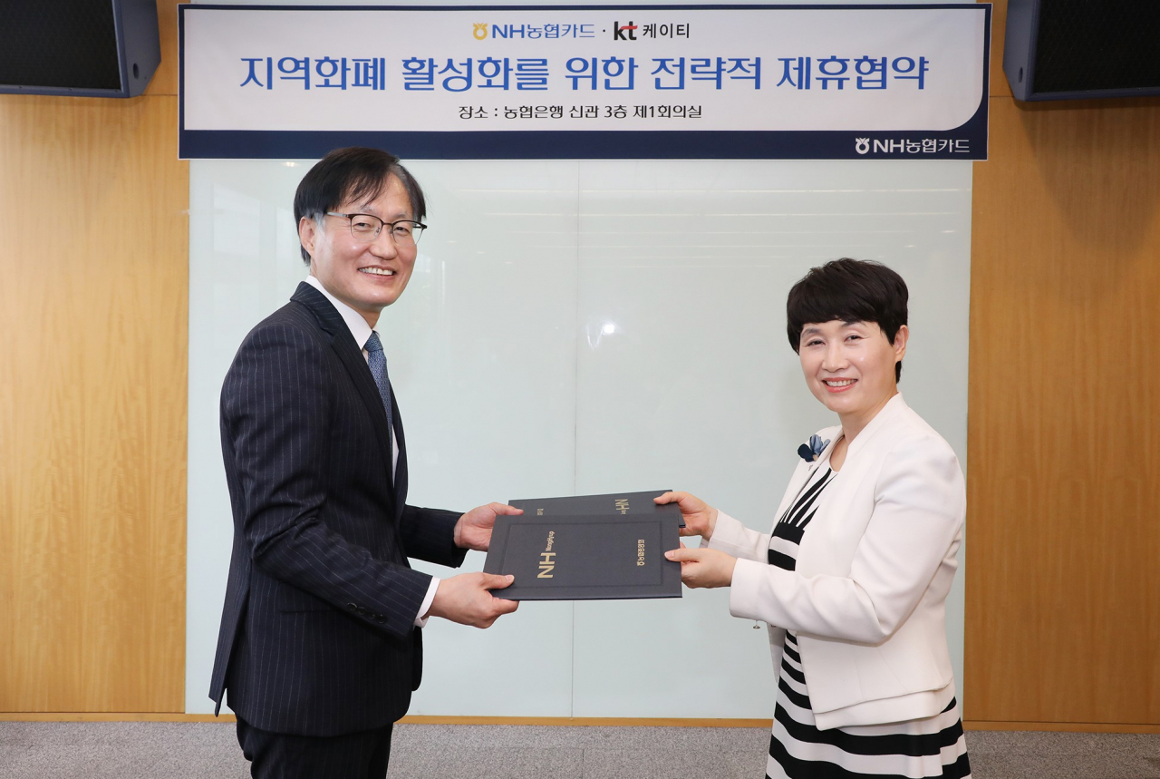 KT와 농협카드는 지역화폐 활성화를 위한 업무협약을 체결했다고 26일 밝혔다. 사진은 김준근 KT 전무와 이수경 NH농협카드 부사장이 업무협약 체결 후 포즈를 취한 모습 [KT 제공]
