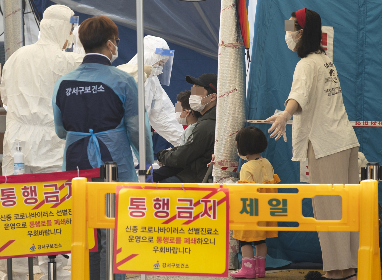 26일 오전 부모님과 함께 서울 강서구 보건소 선별진료소를 찾은 어린이가 신종 코로나바이러스 감염증(코로나19) 검사를 받고 있다. [연합]