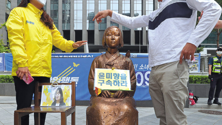 정의기억연대(정의연) 회계 투명성 문제 등을 폭로한 일본군 위안부 피해자 이용수 할머니의 2차 기자회견이 열린 25일 오후 서울 종로구 옛 일본대사관 앞에서 새마을청년연합 관계자가 소녀상에 윤미향 구속 촉구 팻말을 놓은 후 옆에 있던 반아베반일청년학생공동행동 관계자와 실랑이를 하고 있다. [연합]