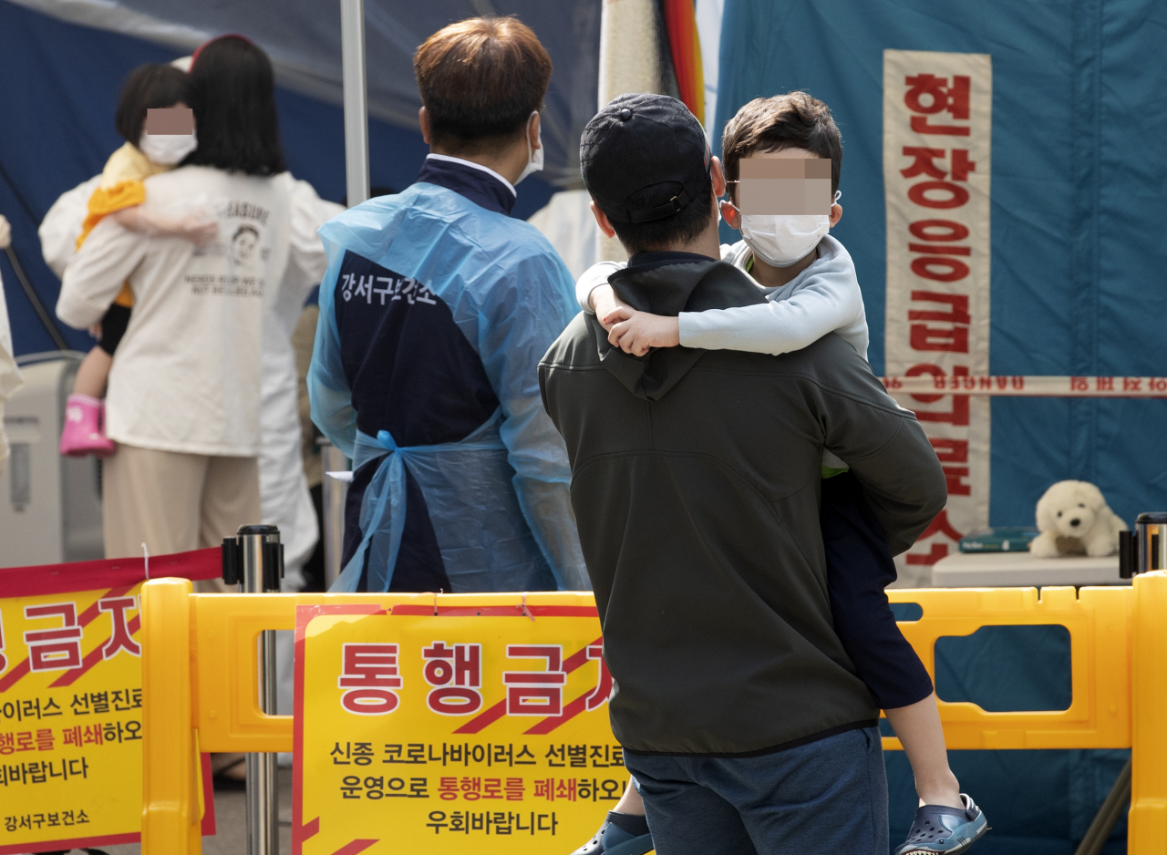 26일 오전 부모님과 함께 서울 강서구 보건소 선별진료소를 찾은 어린이들이 신종 코로나바이러스 감염증(코로나19) 검사를 받은 후 진료소를 나서고 있다. [연합]