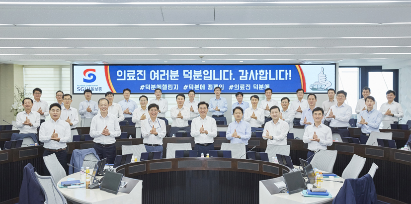 지난 15일 SGI서울보증 김상택(앞줄 가운데) 사장과 임직원들이 코로나19 극복을 위한 ‘덕분에 챌린지’ 캠페인에 참여하고 있다.