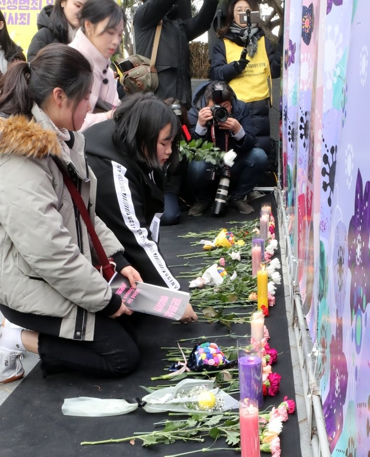 지난해 12월 25일 오후 서울 종로구 옛 일본대사관 앞에서 열린 제1419차 일본군 성노예제 문제해결을 위한 정기 수요시위(수요집회)에서 참석자들이 같은 해 돌아가신 다섯 분의 할머니를 추모하며 헌화하고 있다. [연합]