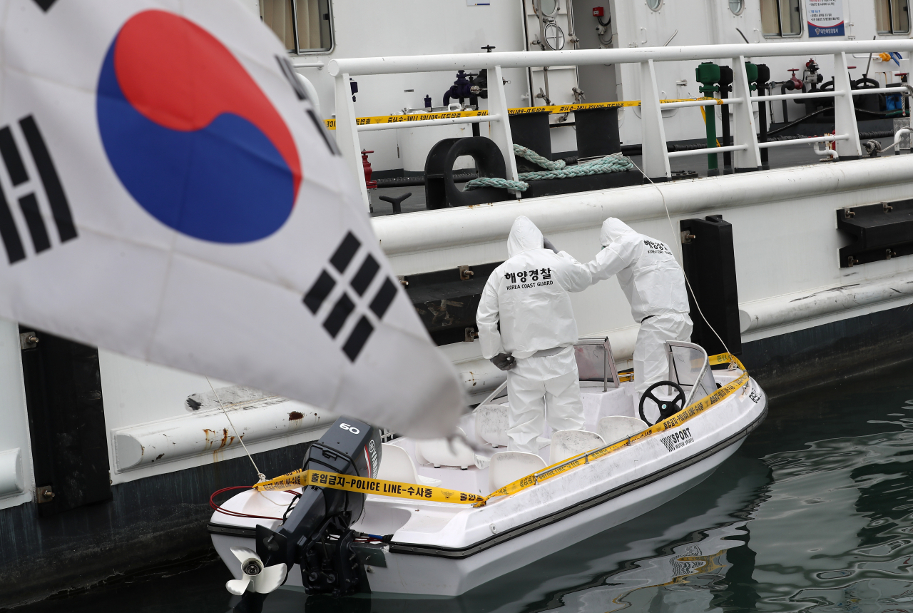 충남 태안 신진항 태안해경 전용부두에서 해경 관계자들이 주민 신고로 발견한 소형 보트를 감식하고 있다.[연합]