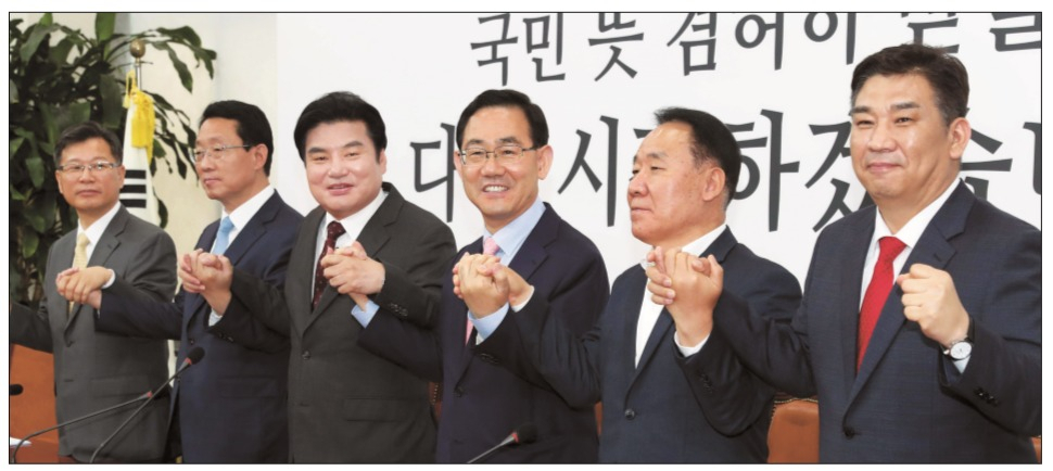 주호영 미래통합당 원내대표(왼쪽에서 4번째)와 원유철 미래한국당 대표(3번째)가 28일 국회에서 양당 간 합당선포식에서 참석자들과 손을 맞잡고 우의를 다지고 있다. [이상섭 기자]