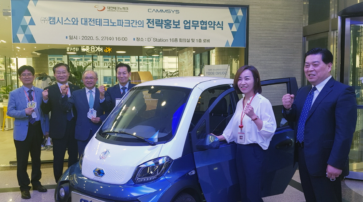 박영태 캠시스 대표(뒷줄 왼쪽 세번째)와 최수만 대전테크노파크 원장(왼쪽 네번째)이 초소형 전기차 ‘CEVO-C’ 앞에서 화이팅을 외치고 있다.[캠시스 제공]