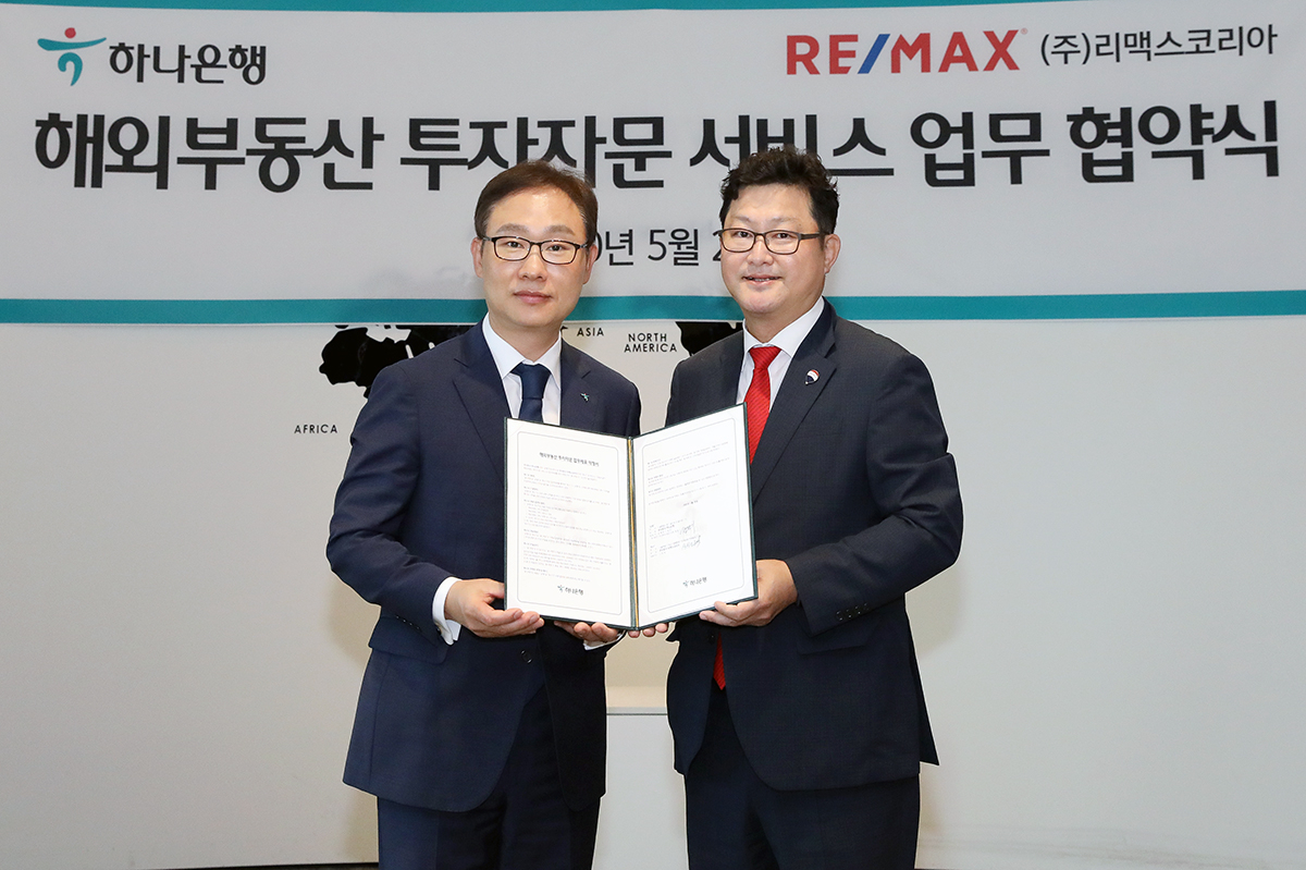 하나은행은 28일 오전 서울시 중구 을지로 본점에서 글로벌 부동산서비스업체 리맥스코리아 및 도우지엔과 해외 부동산 투자자문 서비스에 대한 업무협약을 체결했다. 협약식 체결 후 정원기 하나은행 자산관리사업단 단장(왼쪽)과 신희성 리맥스코리아 대표이사(오른쪽)가 기념촬영을 하고 있다. [사진=하나은행]