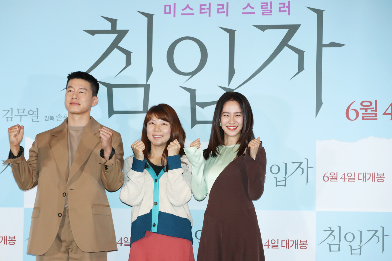 The director of “Intruder” poses for photos with the two lead actors during a press conference in Seoul on Wednesday. From left: actor Kim Mu-yeol, director Sohn Won-pyung and actress Song Ji-hyo. (Yonhap)