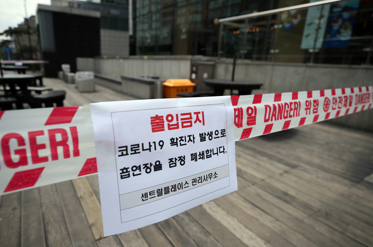 28일 서울 중구 서소문로 센트럴플레이스 앞 흡연구역에 출입금지 안내문이 부착돼 있다. 전날 이 건물 7층에 위치한 KB생명 영업지점에서 직원 1명이 코로나19 확진 판정을 받으면서 직장 동료 약 100명이 격리되고 빌딩 해당 층이 폐쇄됐다. 연합뉴스