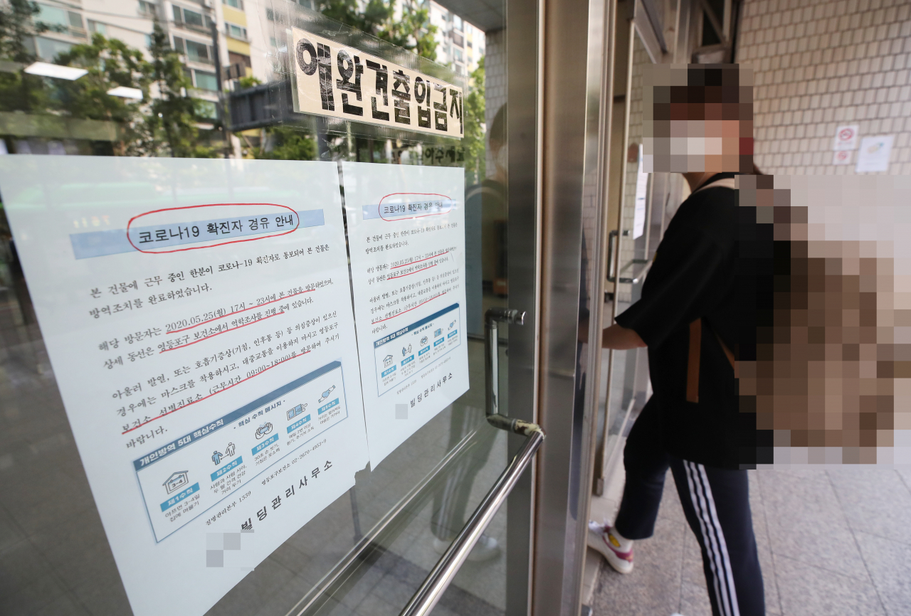코로나19 확진 판정을 받은 강사가 근무하고 있는 학원이 위치한 서울 여의도의 한 빌딩에 25일 '코로나19 확진자 경유 안내문'이 붙어 있다. [사진=연합]