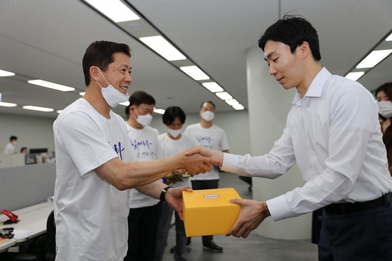 서울 LS용산타워에서 문창배 LS메탈 노조위원장(왼쪽)이 28일 영업사원들에게 빵과 음료를 전달하며 악수를 나누고 있다. [LS 제공]