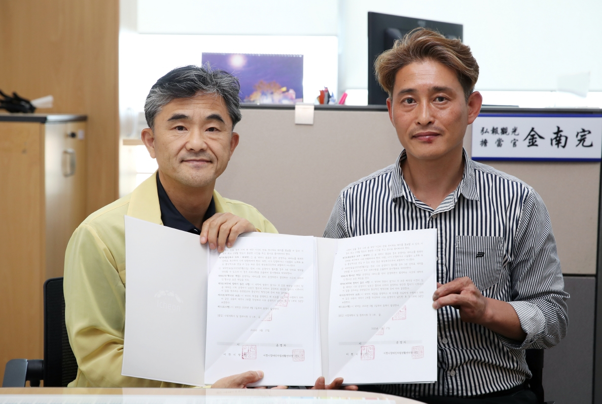 이천시 김남완 홍보관광담당(왼쪽)이 자립생활센터 관계자와 하천관광용 자전거대여소 관리운영계약을 맺고 기념촬영하고 있다. [이천시 제공]
