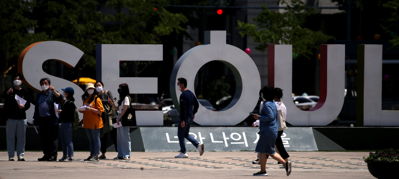 28일 서울 중구 태평로 서울광장에서 시민들이 마스크를 쓴 채 오가고 있다. 지난 6일 방역 체계가 '사회적 거리두기'에서 '생활속 거리두기' 체계로 전환하면서 제시된 신종 코로나 바이러스 감염증(코로나19) '일평균 신규 확진자 50명(미만)' 기준을 최근 상회하면서 현행 방역체계에 변화가 있을지 주목되고 있다. [연합]