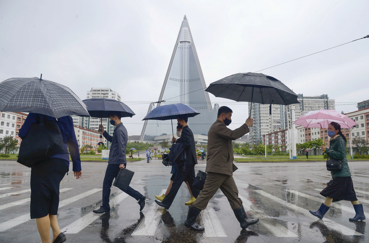 지난 15일 평양 류경호텔 앞을 마스크를 쓴 평양 시민들이 걸어가는 모습. [로이터]