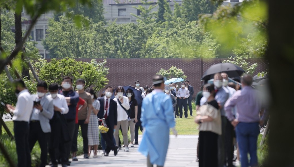 지난달 29일 오전 서울 중구 서소문역사공원에 마련된 임시 선별진료소에서 인근 직장인과 주민들이 신종 코로나바이러스 감염증(코로나19) 검사를 받기 위해 줄을 서서 대기하고 있다. [연합]