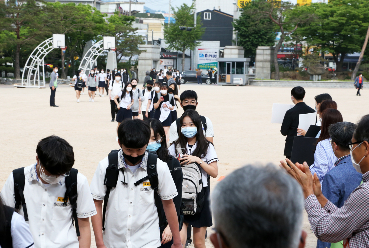 고등학교 1학년·중학교 2학년·초등학교 3&sim;4학년을 대상으로 한 3차 등교개학일인 3일 오전 경북 포항 남구 연일읍 영일고에서 교사들 환영 속에서 1학년 학생들이 올해 처음으로 등교하고 있다. 1학년 학생들은 그동안 신종 코로나바이러스 감염증 사태로 등교하지 못했다. 연합뉴스