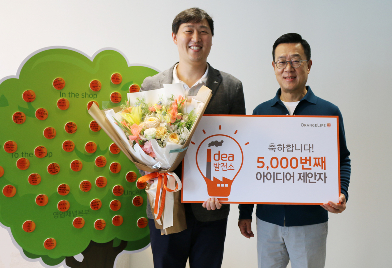 서울 중구 순화동 오렌지센터에서 5000번째 아이디어를 제안한 오렌지라이프 직원과 정문국 사장이 기념촬영을 하고 있다. 출처=오렌지라이프