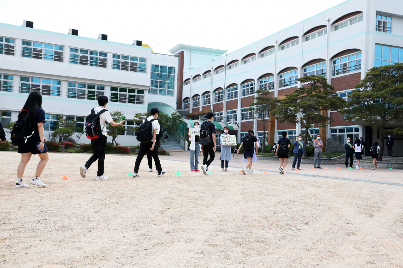 고등학교 1학년·중학교 2학년·초등학교 3&sim;4학년을 대상으로 한 3차 등교개학일인 3일 오전 경북 포항 남구 연일읍 영일고에서 교사들 환영 속에서 1학년 학생들이 등교하고 있다. [연합]