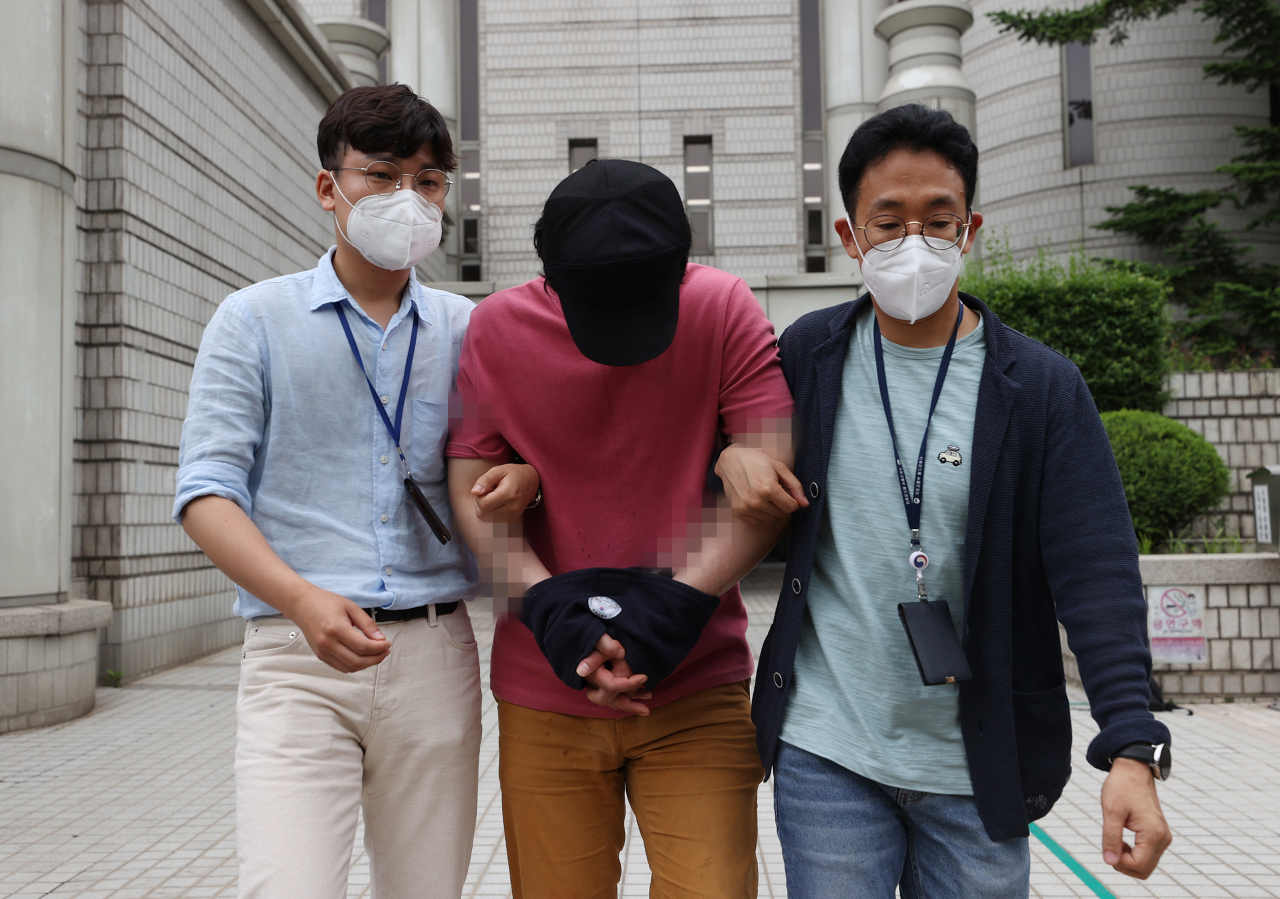서울역에서 처음 보는 여성을 폭행하고 달아났다가 검거된 이모씨가 4일 오후 서울 서초구 서울중앙지법에서 열린 영장실질심사에 출석한 뒤 법원을 나서고 있다. 이씨는 지난달 26일 공항철도 서울역 1층에서 모르는 사이인 30대 여성의 왼쪽 광대뼈 부위 등을 가격해 상처를 입히고 도주한 혐의를 받는다. [연합]