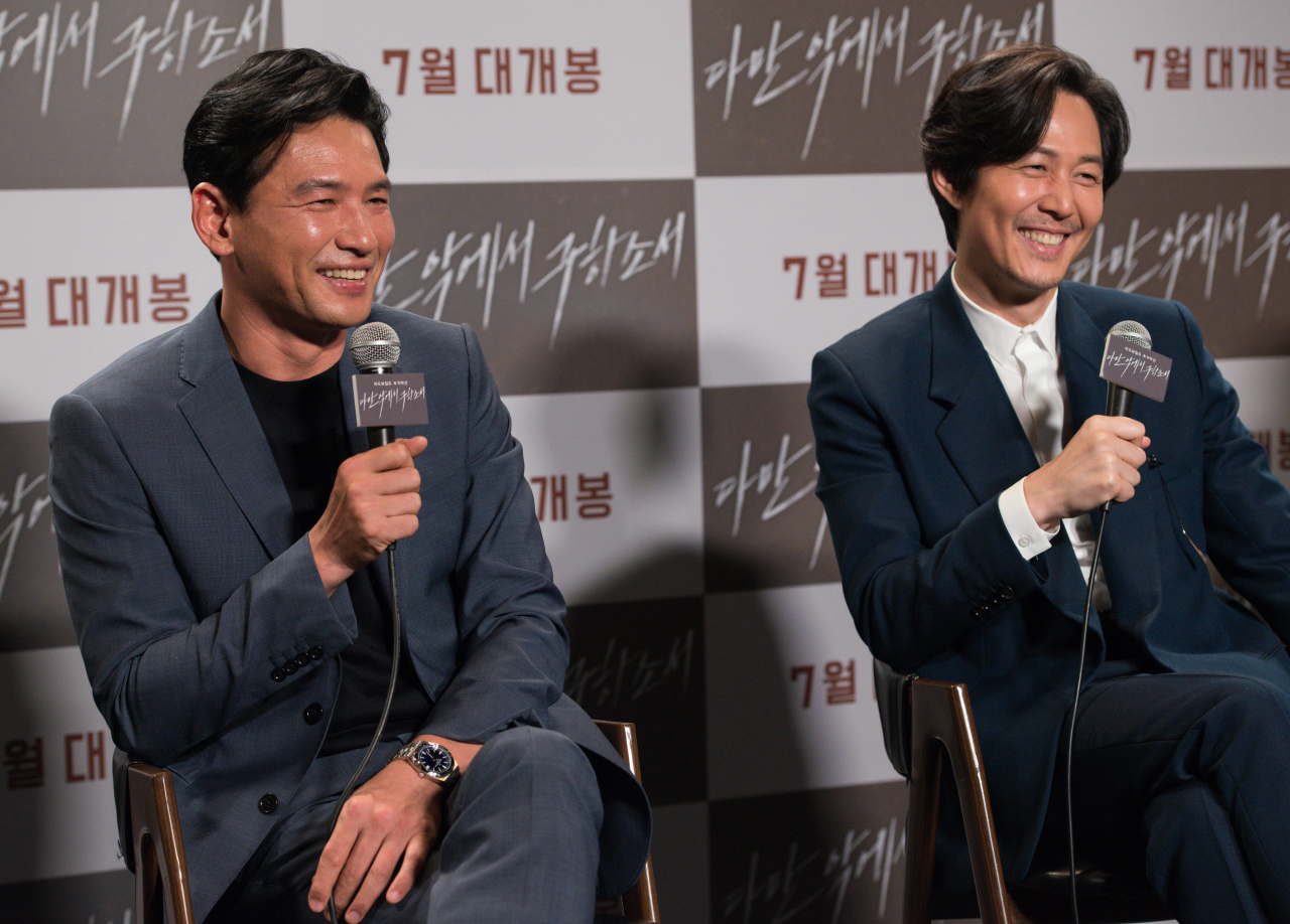 Leading men Hwang Jung-min (left) and Lee Jung-jae attend a press conference Friday to promote “Deliver Us From Evil.” (CJ Entertainment)