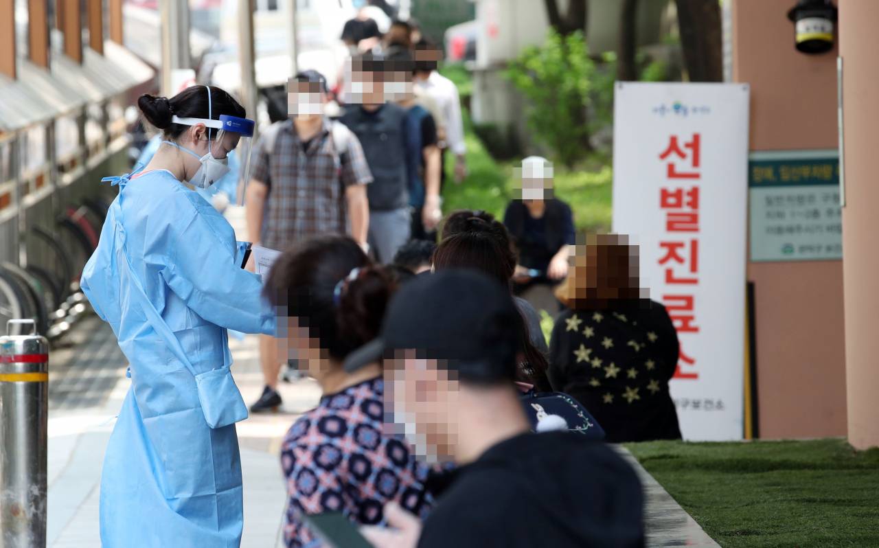 지난 5일 오후 서울 관악구보건소 앞에 마련된 신종 코로나바이러스 감염증(코로나19) 선별진료소에서 의료진들이 시민들의 진료 접수를 돕고 있다. [연합]