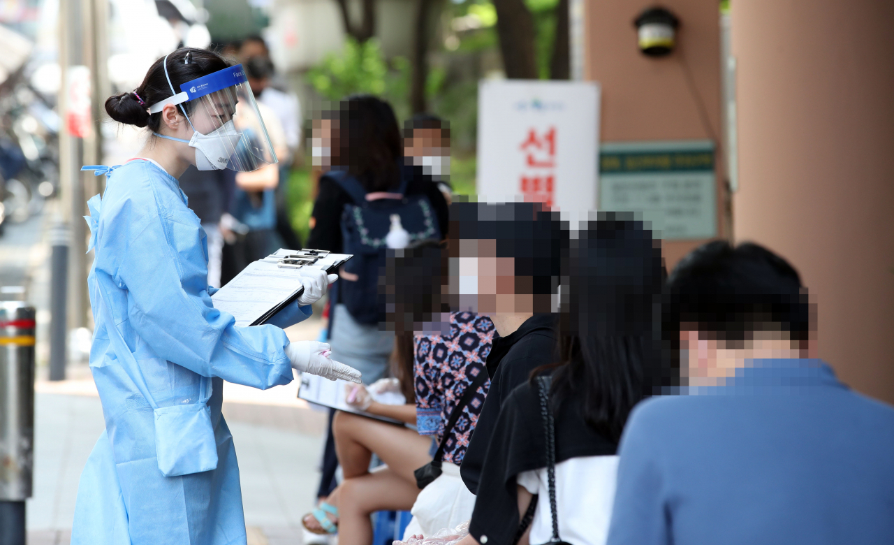 5일 오후 서울 관악구보건소 앞에 마련된 신종 코로나바이러스 감염증(코로나19) 선별진료소에서 의료진들이 진료에 앞서 상담해주고 있다. [연합]
