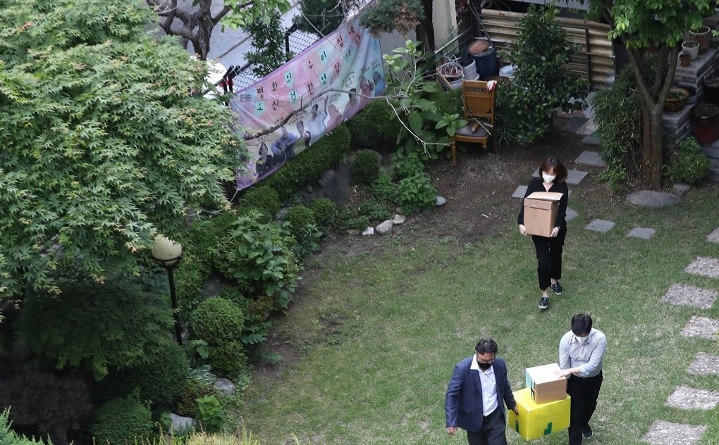 Prosecution investigators move boxes containing seized items out of a shelter for victims of Japan's wartime sexual slavery, which is owned by the Korean Council for Justice and Remembrance for the Issues of Military Sexual Slavery by Japan, in Seoul on May 21, 2020.(Yonhap)