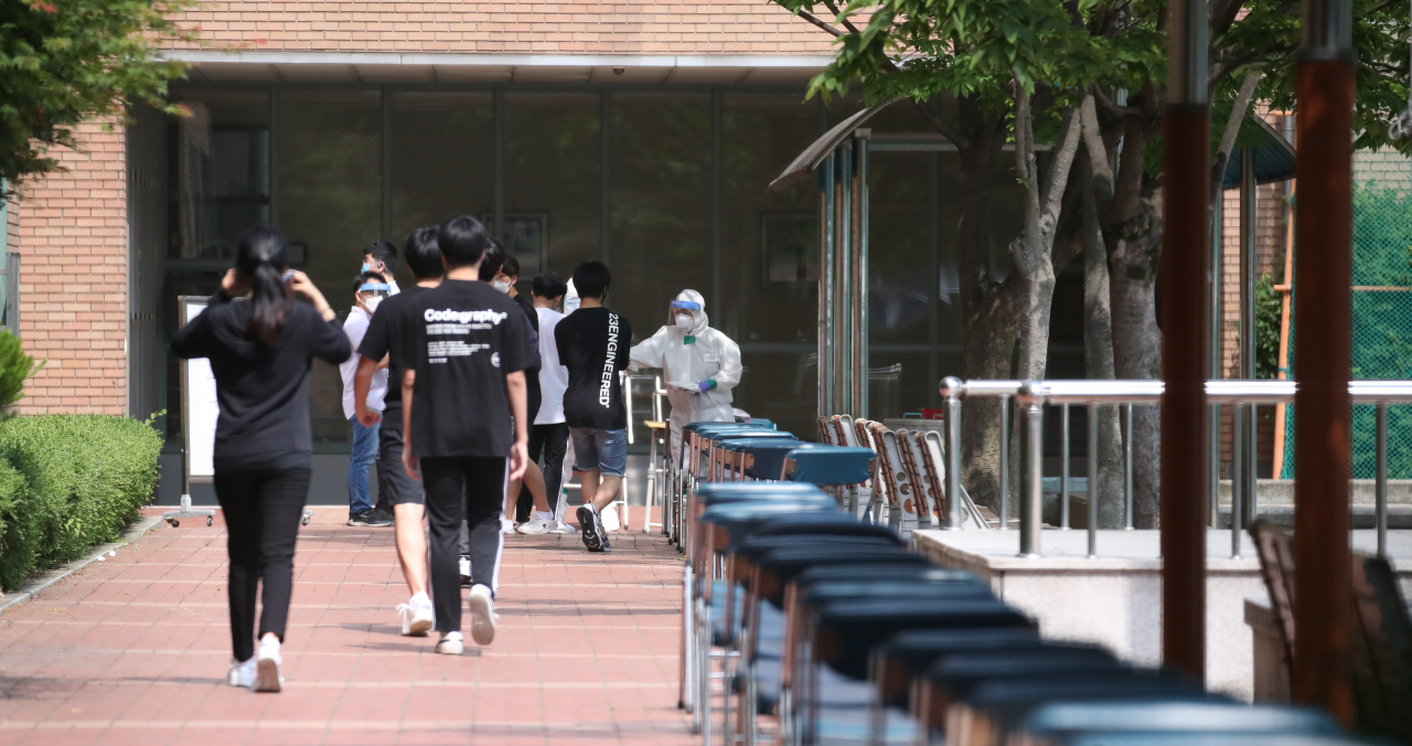8일 서울 중랑구 원묵고등학교에 마련된 선별진료소에서 이 학교 학생, 교직원들이 신종 코로나 바이러스 감염증(코로나19) 검사를 받기 위해 차례를 기다리고 있다. 전날 이 학교 3학년 학생이 코로나19에 감염된 것으로 확인됨에 따라 원묵고는 등교 중지와 함께 학생·교직원에 대한 전수조사에 들어갔다. 우선 이날부터 10일까지 전 학년이 온라인 수업으로 전환한다. [연합]