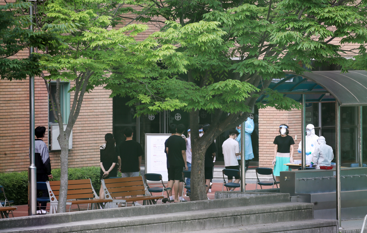 8일 서울 중랑구 원묵고등학교에 마련된 선별진료소에서 이 학교 학생, 교직원들이 신종 코로나바이러스 감염증(코로나19) 검사를 받기 위해 차례를 기다리고 있다. 전날 이 학교 3학년 학생이 코로나19에 감염된 것으로 확인됨에 따라 원묵고는 등교 중지와 함께 학생·교직원에 대한 전수조사에 들어갔다. [연합]