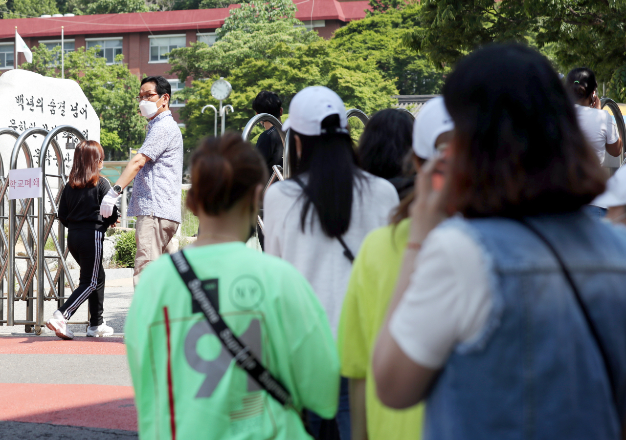 인천지역에 신종 코로나바이러스 감염증(코로나19) 확진자가 속출한 9일 오전 확진자가 나온 인천시 미추홀구 한 초등학교 앞에서 학부모들이 검체 검사를 받는 자녀들을 기다리고 있다. 연합뉴스