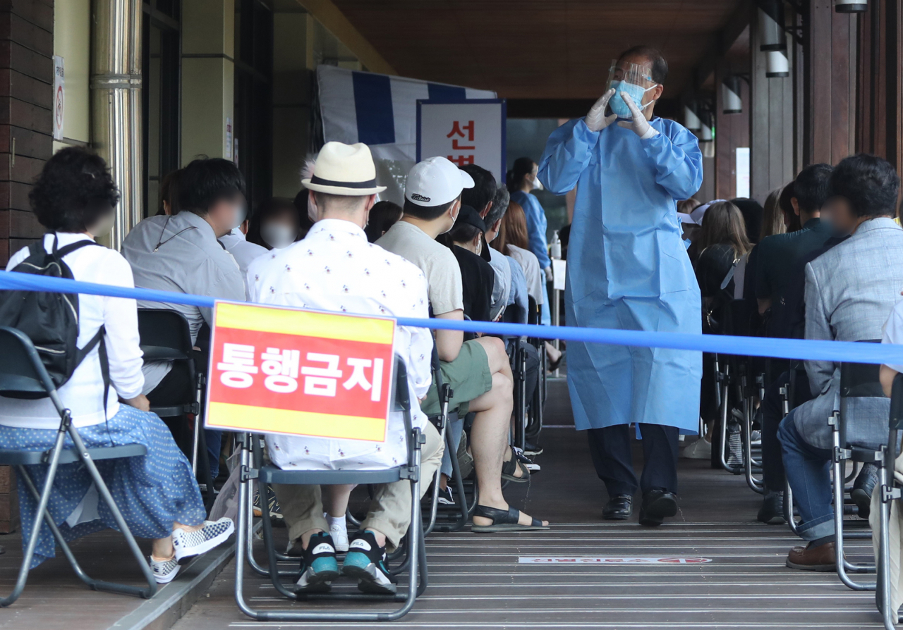 8일 송파구 보건소 선별진료소가 코로나19 검사를 받는 시민들로 붐비고 있다. 전날 송파구 보건소 인근의 롯데월드는 확진자 방문으로 영업을 중단했다. [연합]