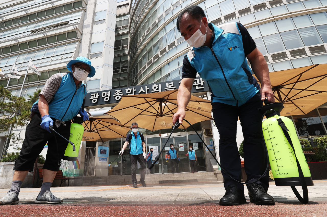 입소자 3명과 종사자 3명이 전날 밤 신종 코로나바이러스 감염증(코로나19) 확진 판정을 받은 경기도 광명시 광명어르신보호센터가 입주한 광명종합사회복지관 앞에서 9일 오후 광명3동자율방재단원들이 주변 방역을 하고 있다. 연합뉴스