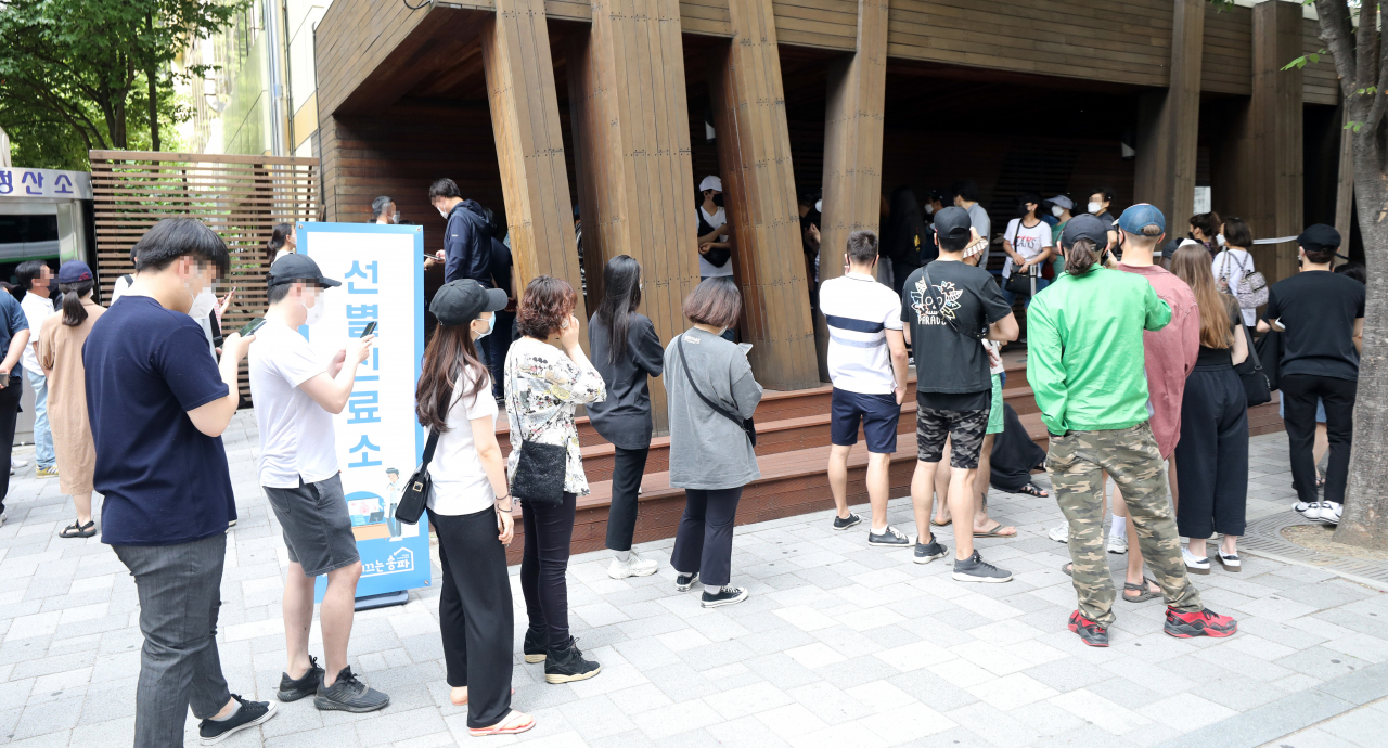 8일 송파구 보건소 선별진료소가 코로나19 검사를 받는 시민들로 붐비고 있다. 전날 송파구 보건소 인근의 롯데월드는 확진자 방문으로 영업을 중단했다. [연합]