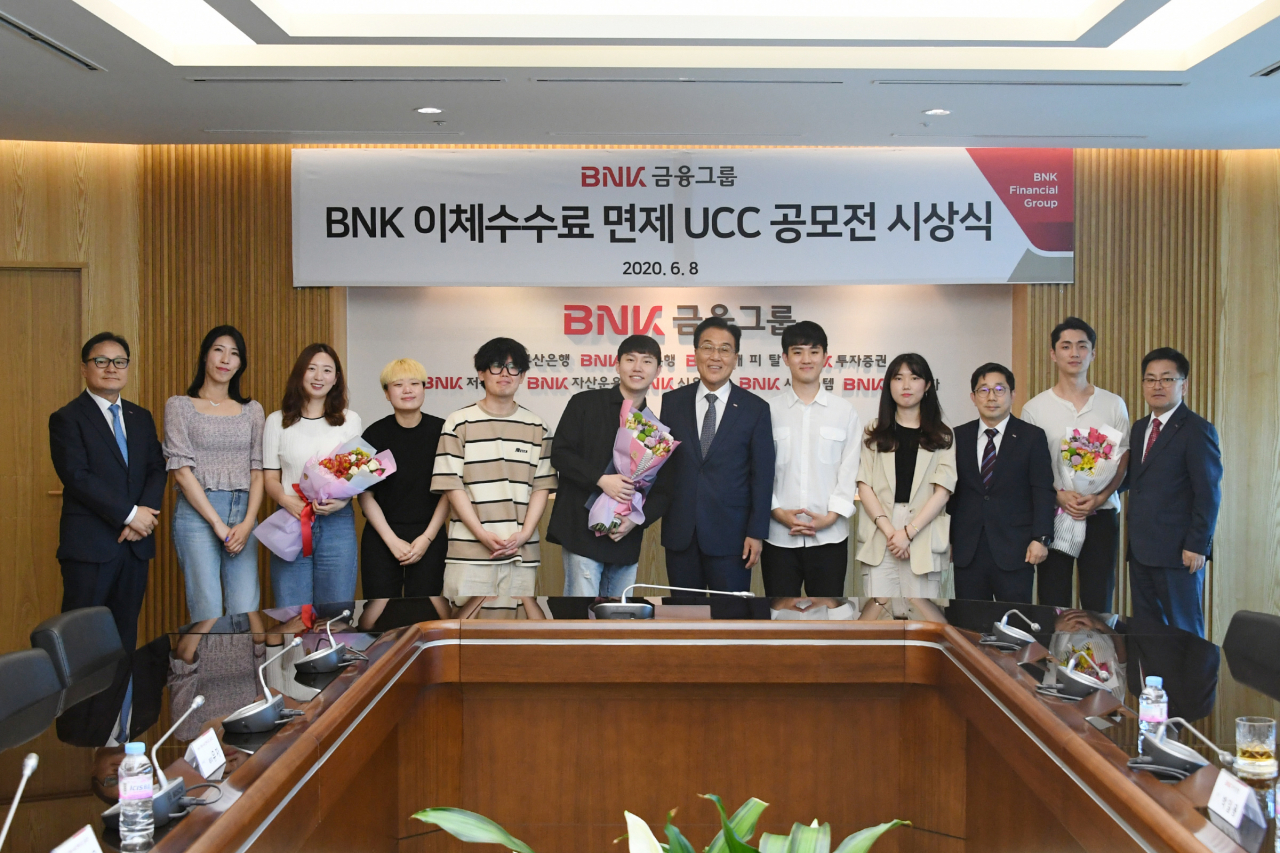 BNK금융그룹이 8일 오후, 본사에서 ‘인터넷·모바일뱅킹 이체수수료 면제’를 주제로 진행한 UCC 공모전의 시상식을 개최했다. (사진 오른쪽 여섯번째부터 BNK금융그룹 김지완 회장, BNK대상 수상자 강범철씨) 출처=BNK금융그룹