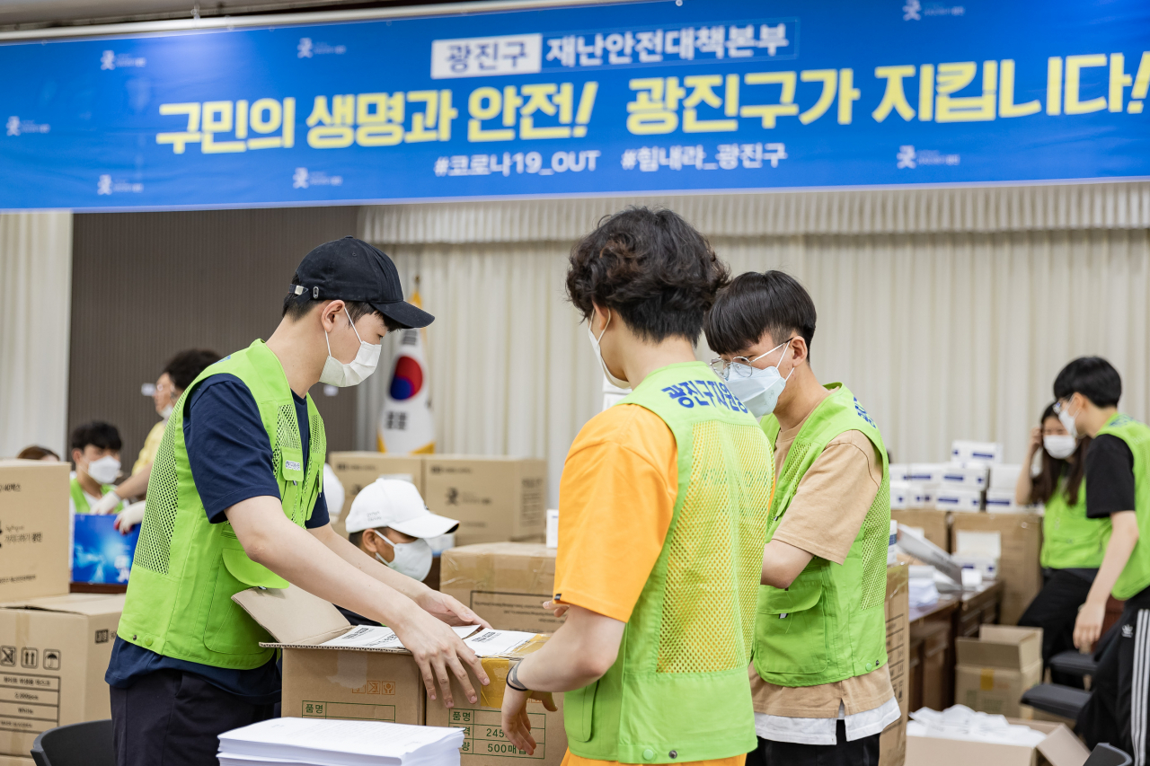 지난 9일 광진구청 대강당에서 학교에 배부할 마스크 포장 작업을 진행하고 있는 자원봉사자들 모습. [광진구 제공]