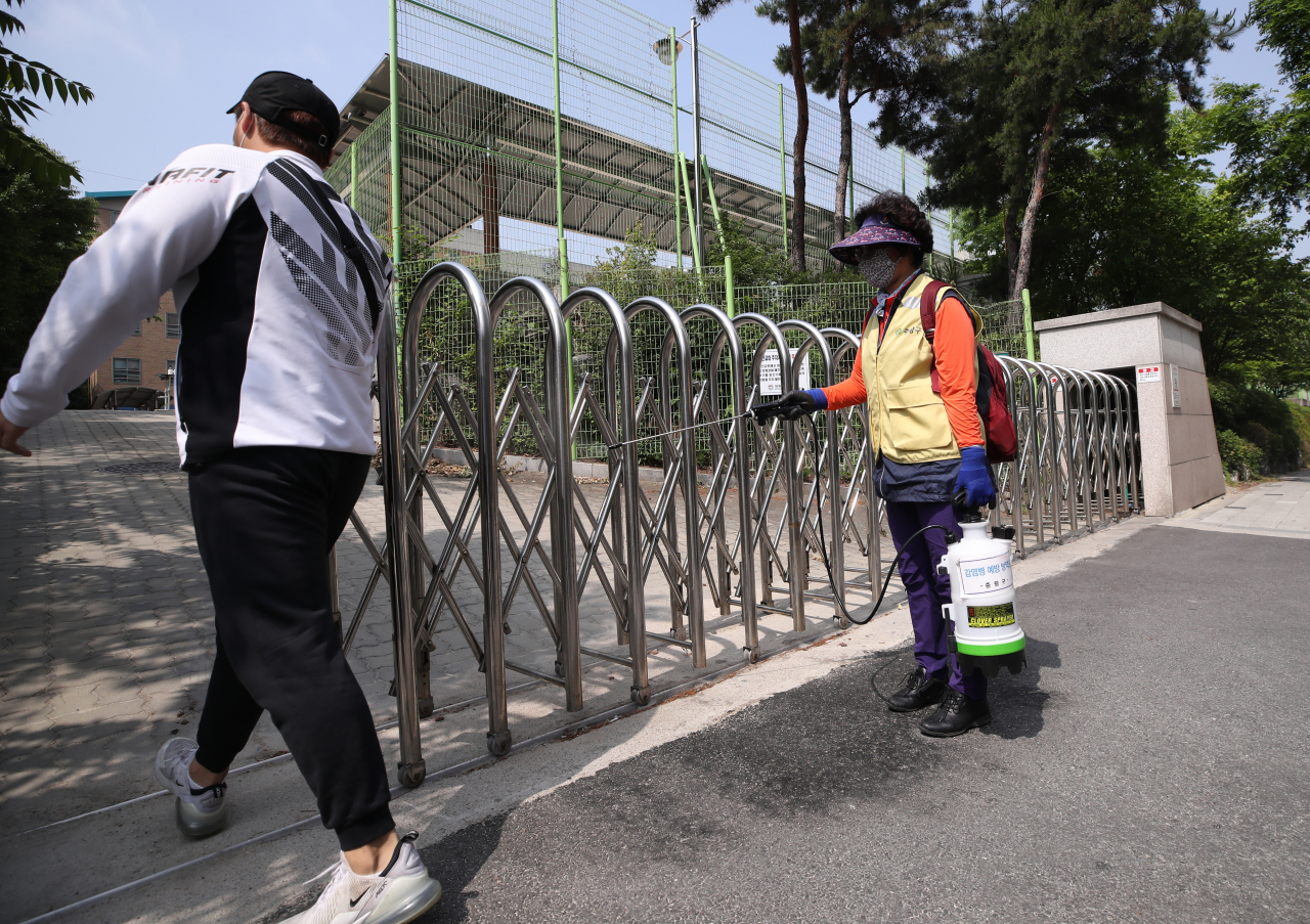 8일 서울 중랑구 원묵고등학교 입구에서 중랑구 감염병 예방 방역단 관계자가 소독을 하고 있다. 전날 이 학교 3학년 학생이 코로나19에 감염된 것으로 확인됨에 따라 원묵고는 등교 중지와 함께 학생·교직원에 대한 전수조사에 들어갔다. [연합]