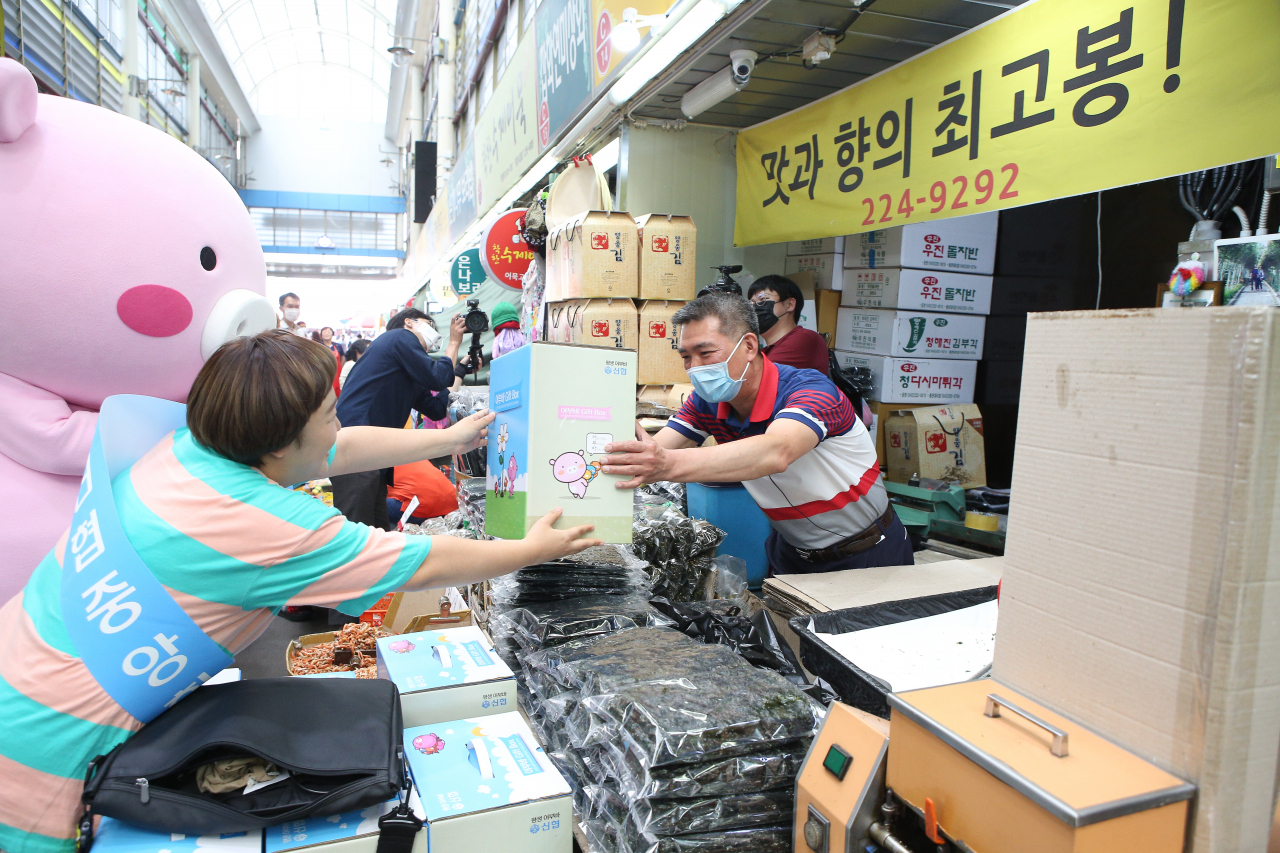 신협중앙회가 9일 개그우먼 윤효동씨와 전통시장 소상공인 응원 및 어부바 박스 증정 행사를 진행하는 모습 [신협중앙회 제공]