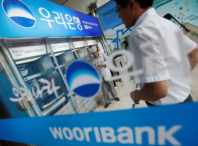 Customers use ATMs at a Woori Bank branch in Seoul (Reuters)