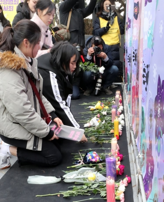지난해 12월 25일 오후 서울 종로구 옛 일본대사관 앞에서 열린 제1419차 일본군 성노예제 문제해결을 위한 정기 수요시위(수요집회)에서 참석자들이 같은 해 돌아가신 다섯 분의 할머니를 추모하며 헌화하고 있다. [연합]