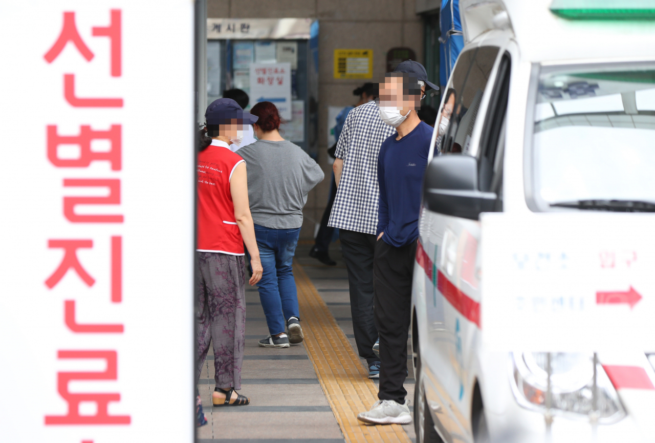 서울 도봉구 성심데이케어센터에서 신종 코로나바이러스 감염증(코로나19) 집단 발병이 발생한 가운데 12일 도봉구 보건소 선별진료소를 찾은 시민들이 검사를 받기 위해 대기하고 있다. 연합뉴스