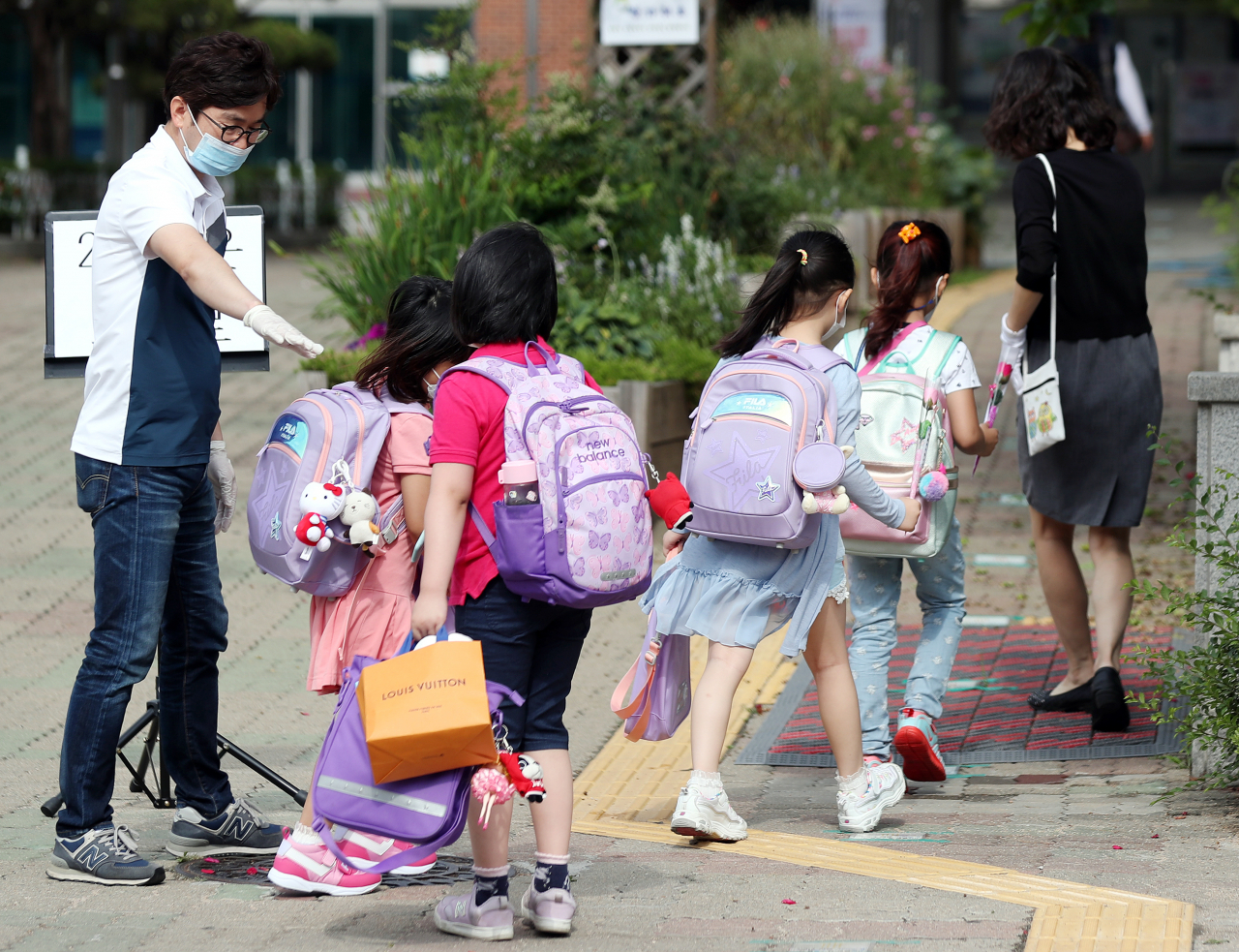 경기 부천 지역 특수학교, 유치원, 초·중·고등학교(고 3 제외) 등교수업이 시작된 11일 오전 경기도 부천시 송내동 솔안초등학교에서 처음 입학한 학생들이 교사의 안내에 따라 학교 건물로 들어서고 있다. [연합]
