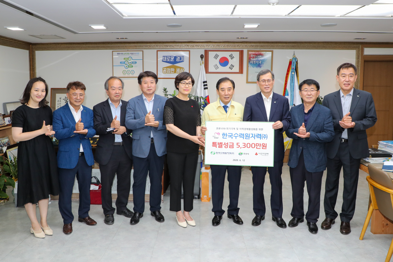 정재훈(오른쪽 세번째) 한국수력원자력 원장이 12일 경기 포천시청에서 열린 특별성금 전달식에 기념촬영을 하고 있다. [연합]