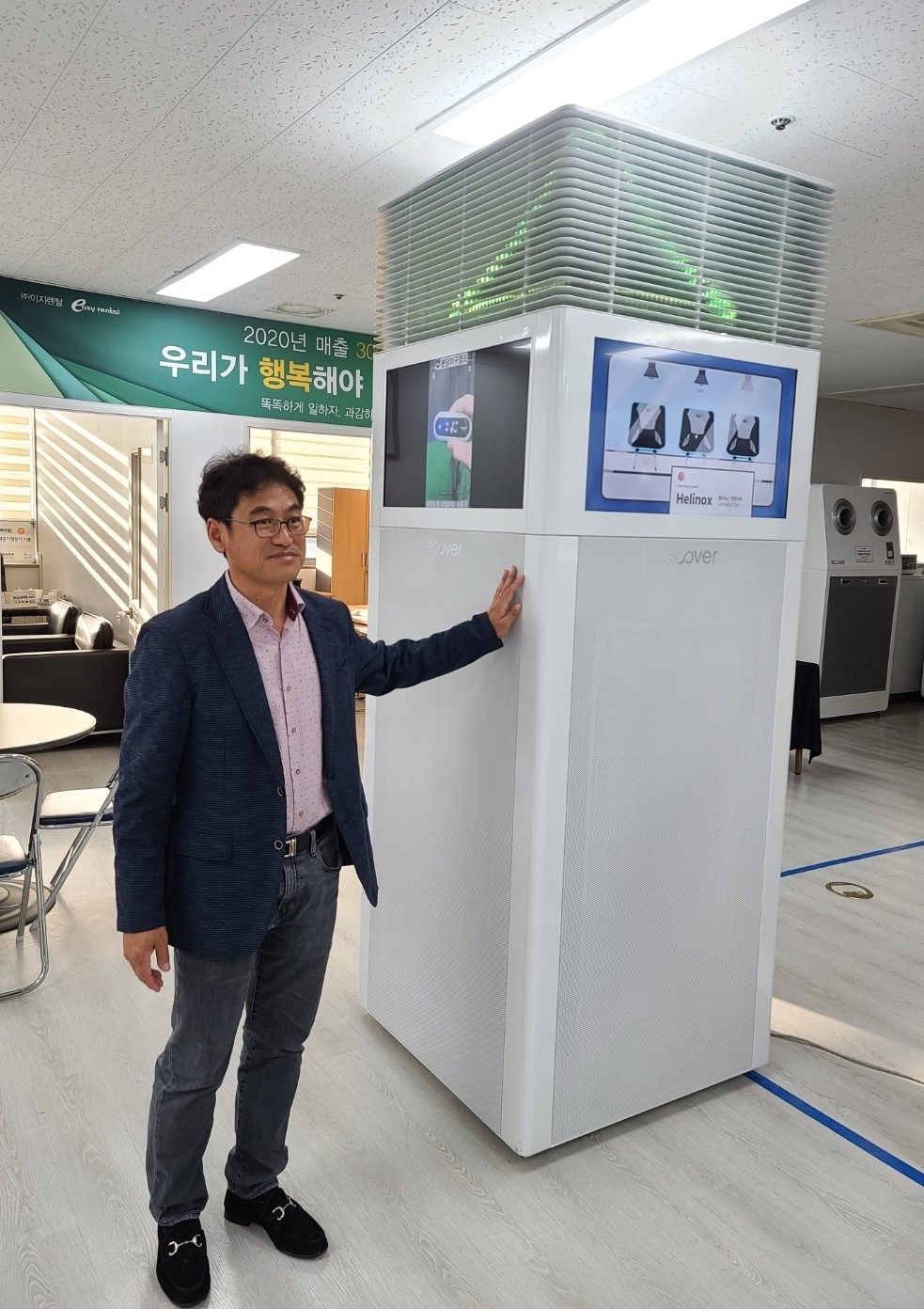 박무병 이지렌탈 회장이 광고판을 설치한 타워형 초대형 공기청정기를 선보이고 있다.[이지렌탈 제공]