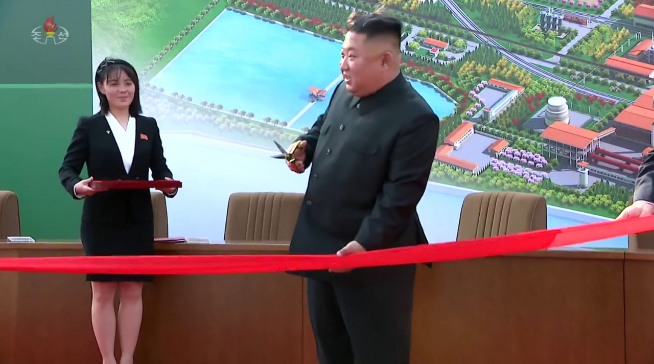 북한 김정은 국무위원장이 노동절(5.1절)이었던 지난달 1일 순천인비료공장 준공식에 참석하고 있다. 김여정 당 제1부부장이 옆에 받침대를 들고 서 있다.[연합]