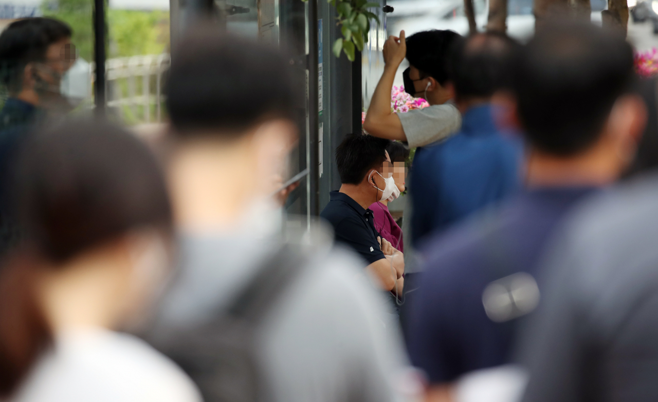 수도권에 집중된 신종 코로나바이러스 감염증(코로나19) 집단발병이 'n차 감염'의 고리를 타고 빠르게 확산하는 가운데 신규 확진자 중 치명률이 높은 60세 이상 고령층의 비율이 급증해 방역 및 환자 관리에 비상등이 켜졌다. 여기에다 감염경로가 명확하지 않은 이른바 '깜깜이 환자'도 갈수록 늘어나는 추세여서 방역당국으로서는 그야말로 '삼중고'를 겪고 있다. 15일 서울 중구의 한 버스 정류장에서 마스크를 쓴 시민들이 출근을 서두르고 있다. [연합]