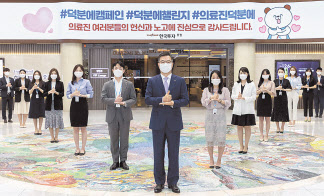 정일문 한국투자증권 사장(가운데)이 여의도 한국투자증권 본사 로비에서 임직원과 함께 ‘덕분에 챌린지’ 캠페인에 동참하고 있다. [한국투자증권 제공]