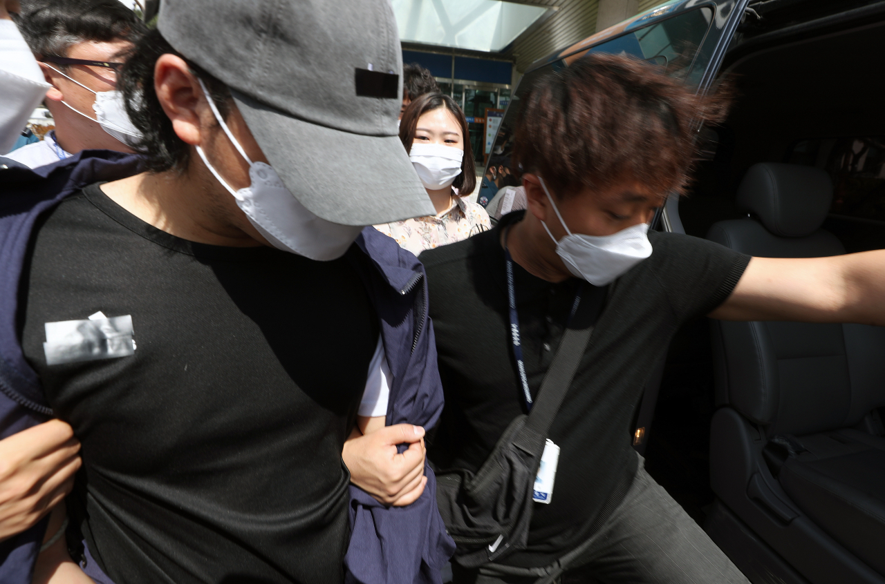 창녕 아동학대 계부(왼쪽)가 15일 오전 영장실질심사(구속 전 피의자 심문)를 받기 위해 경남 밀양경찰서에서 나오고 있다. 이 계부는 자신의 의붓딸을 쇠사슬 등으로 학대한 혐의를 받고 있다. [연합]