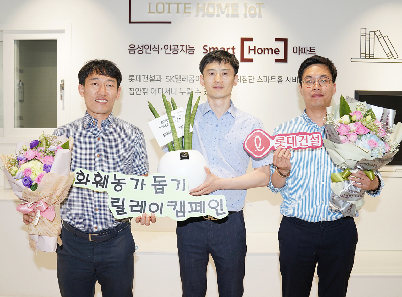 롯데건설 대구 C/S센터 근무자들이 꽃다발과 공기정화 식물이 담긴 화분을 들고있다.[롯데건설 제공]