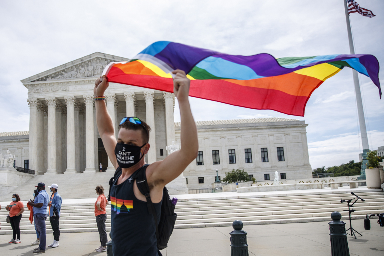 미국 대법원이 성소수자(LGBTQ)도 성별에 따른 차별을 금지한 민권법 7조의 보호 대상이라고 판결한 15일(현지시간) 미국 워싱턴DC의 대법원 건물 앞에서 한 지지자가 무지개색 깃발을 들고 환호하고 있다. [EPA]