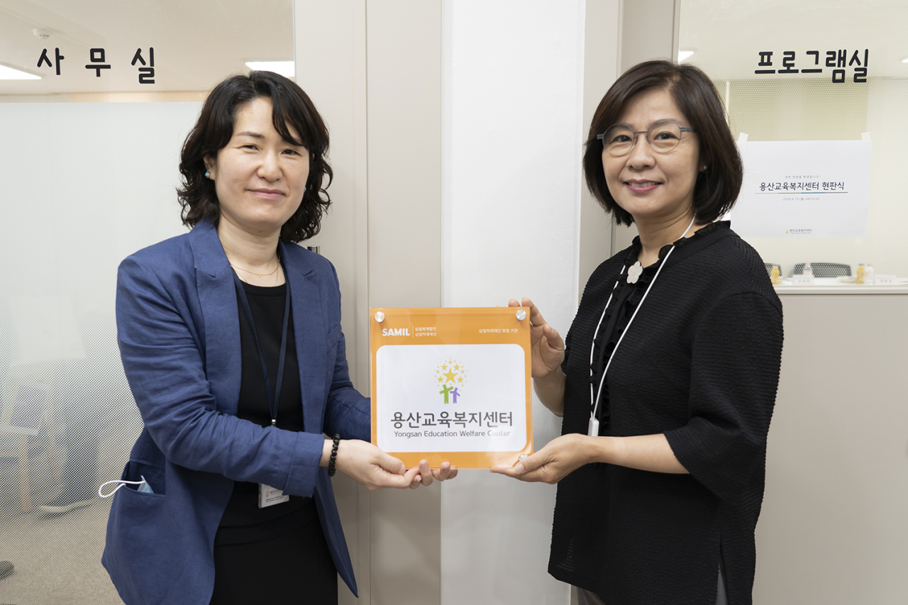 15일 서울 용산구 용산교육복지센터에서 진행된 현판식을 마치고, 용산교육복지센터 박수미 센터장(왼쪽)과 삼일미래재단 정연성 사무총장이 기념촬영을 하고 있다. [삼일회계법인 제공]