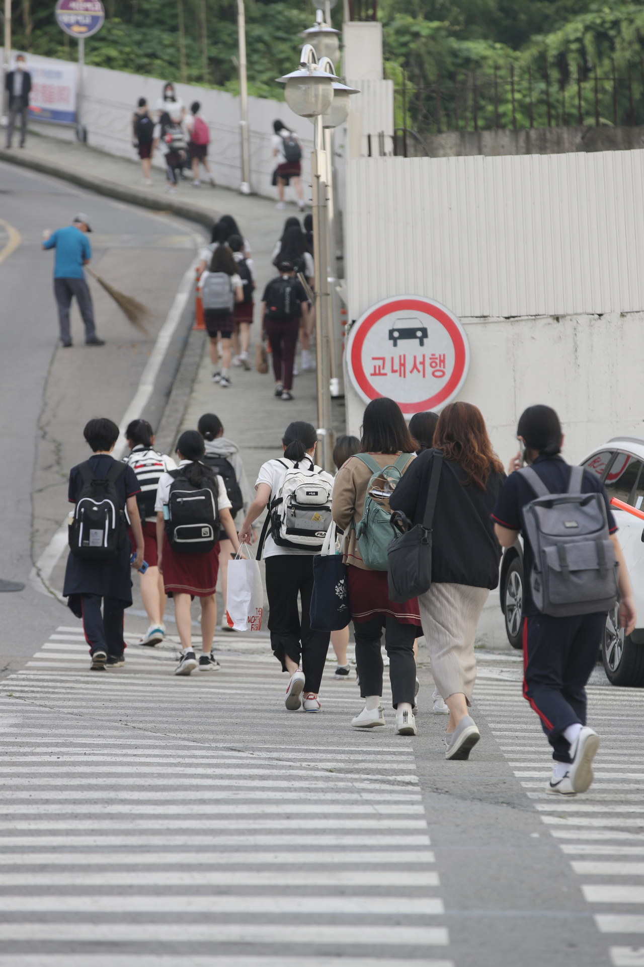 지난 15일 오전 코로나19 의심 학생이 '가짜 양성' 판정을 받은 광주 남구 대광여고에서 학생들이 등교하고 있다. 2주간 온라인 수업을 하려던 시 교육청은 '가짜 양성' 판정이 내려지자 등교 수업을 결정했다. [연합]